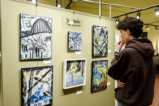 Austin Sullivan, student artist, looking at work of Joan Mullins, March 2023