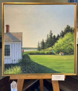 Framed painting of cottage lawn by the water